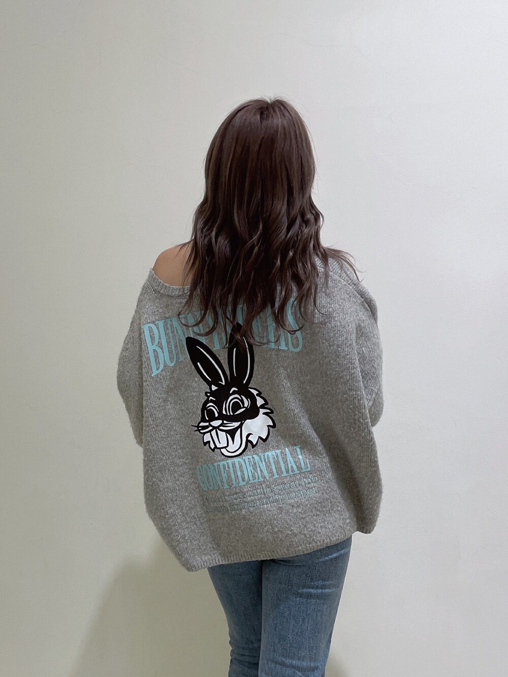 グレー系のニット/セーター、ブルー系のデニムパンツ、ホワイト系のパンプスを着用したレディースの冬コーディネートの3枚目の写真