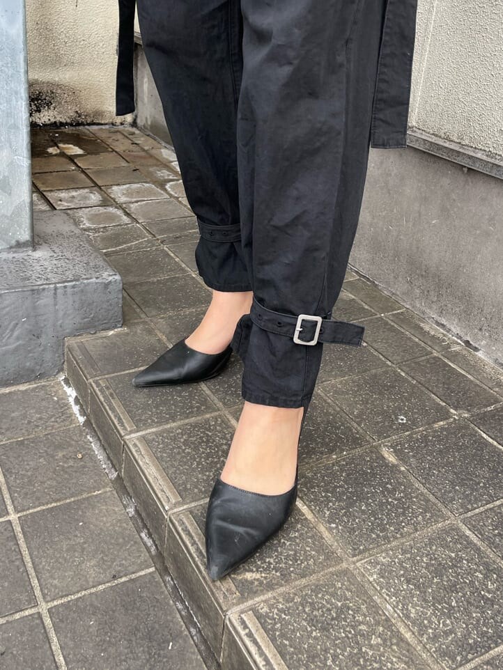 ブラック系のパンプス、ブラック系のスラックス、ブラック系のキャミソールを着用したレディースの春コーディネートの7枚目の写真