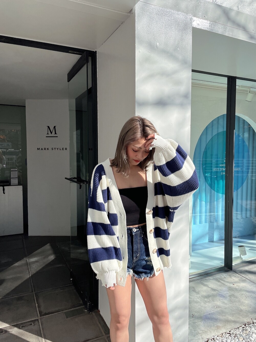 ブルー系のカーディガン/ボレロ、ブラック系のチューブトップ、ブルー系のデニムパンツを着用したレディースの冬コーディネートの4枚目の写真