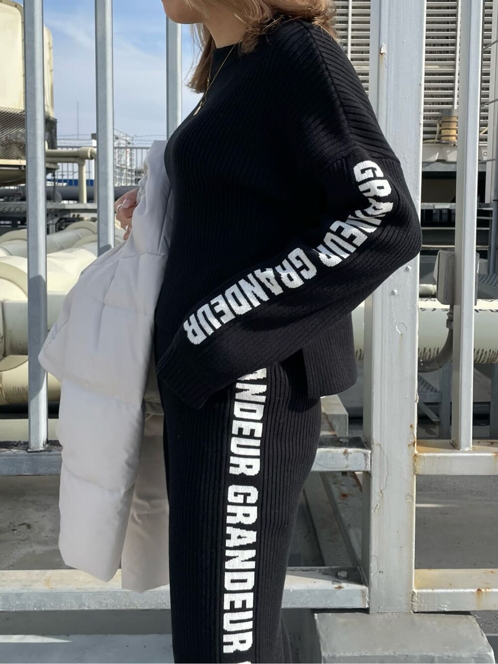 ブラック系のパンプス、ホワイト系のダウンジャケット/コート、ブラック系のその他パンツを着用したレディースの冬コーディネートの6枚目の写真