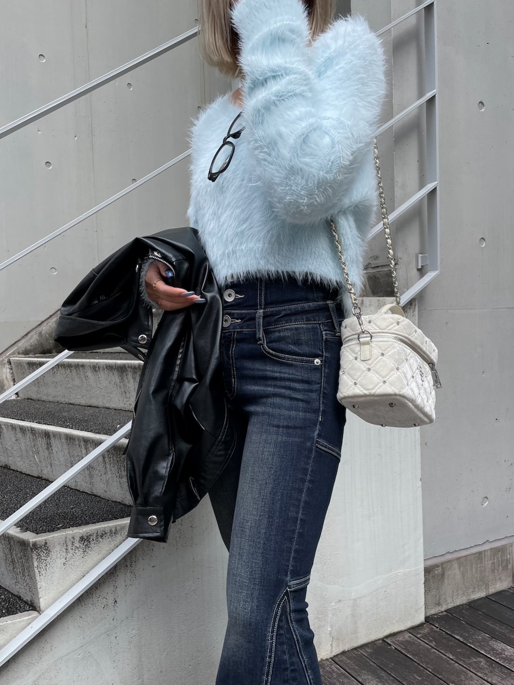 ブルー系のニット/セーター、ブルー系のデニムパンツ、ブラック系のブーツを着用したレディースの秋コーディネートの2枚目の写真