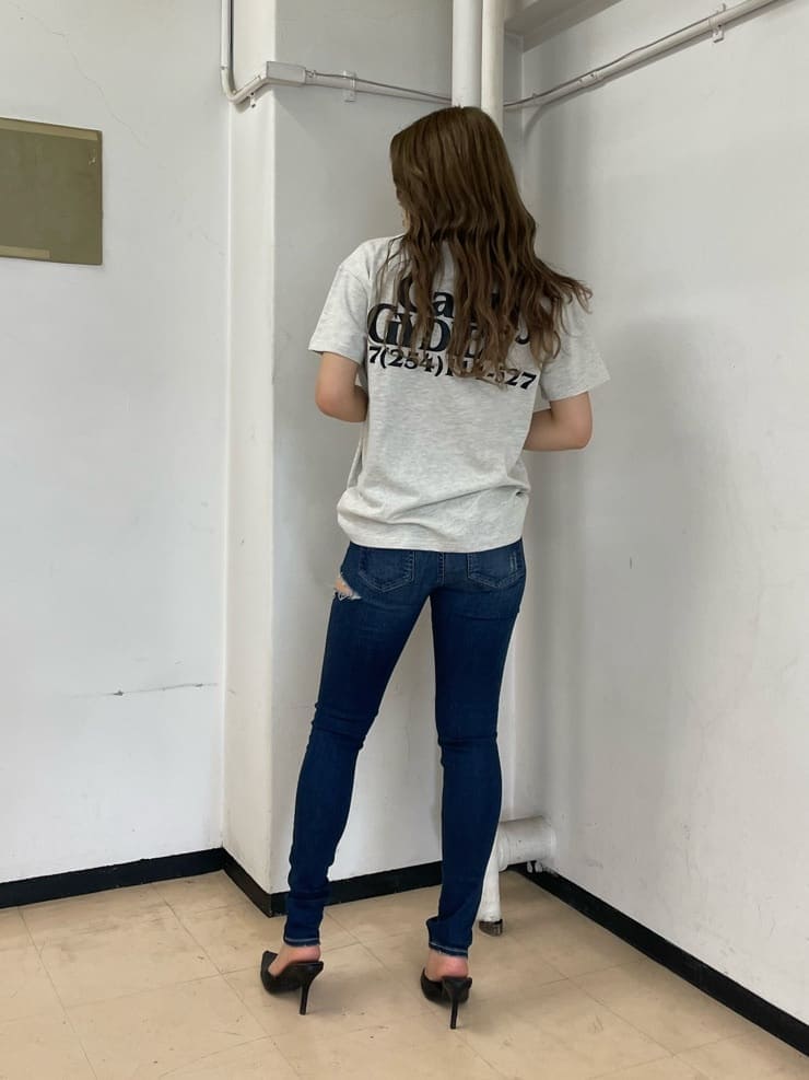 ブラック系のパンプス、ブルー系のデニムパンツ、グレー系のTシャツ/カットソーを着用したレディースの春コーディネートの2枚目の写真