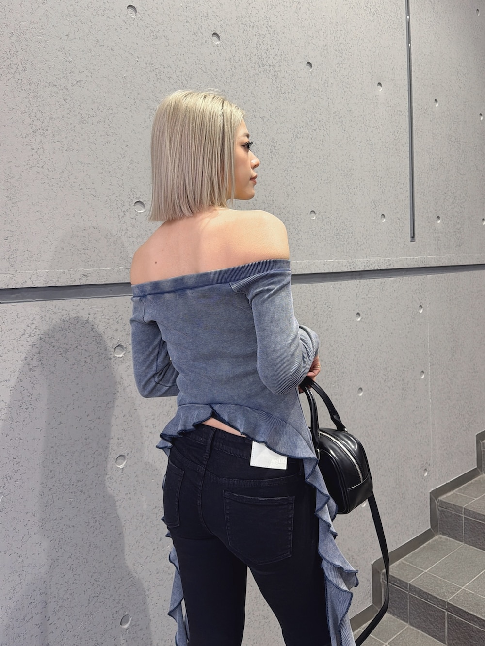 ブルー系のTシャツ/カットソー、ブラック系のハンドバッグ、ブラック系のデニムパンツを着用したレディースの春コーディネートの3枚目の写真