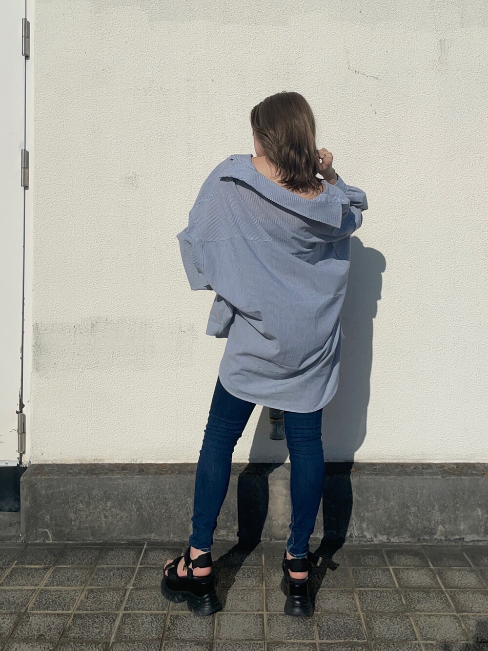 ブルー系のシャツ/ブラウス、ブルー系のデニムパンツ、ブラック系のサンダルを着用したレディースの春コーディネートの2枚目の写真