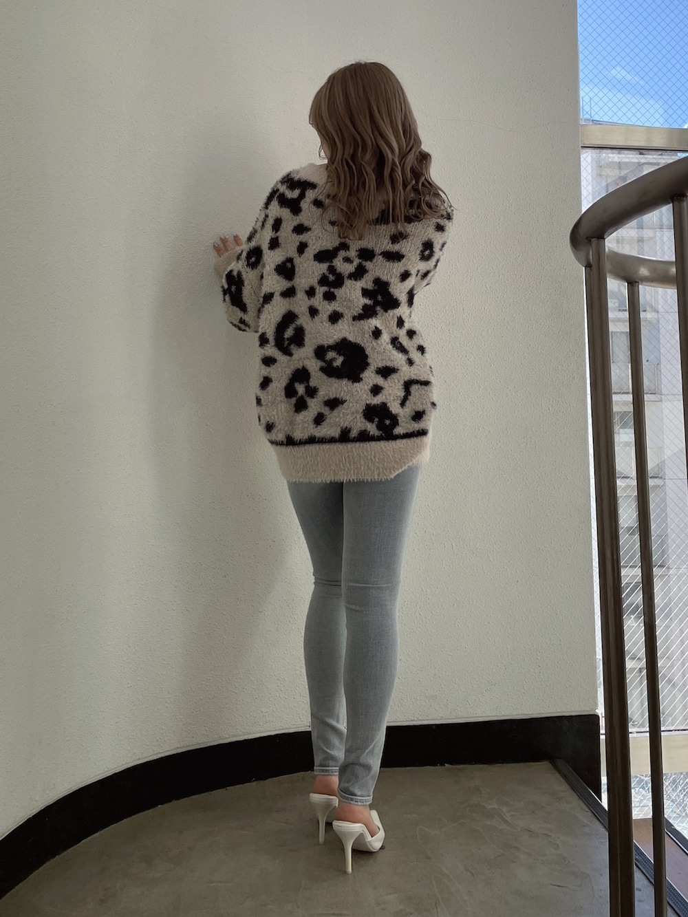 ベージュ系のニット/セーター、ブルー系のデニムパンツ、ホワイト系のパンプスを着用したレディースの冬コーディネートの2枚目の写真