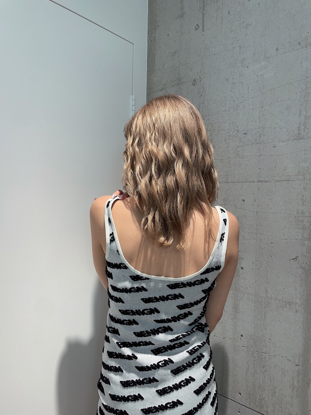 ホワイト系のワンピース、ブラック系のブーツを着用したレディースの夏コーディネートの4枚目の写真