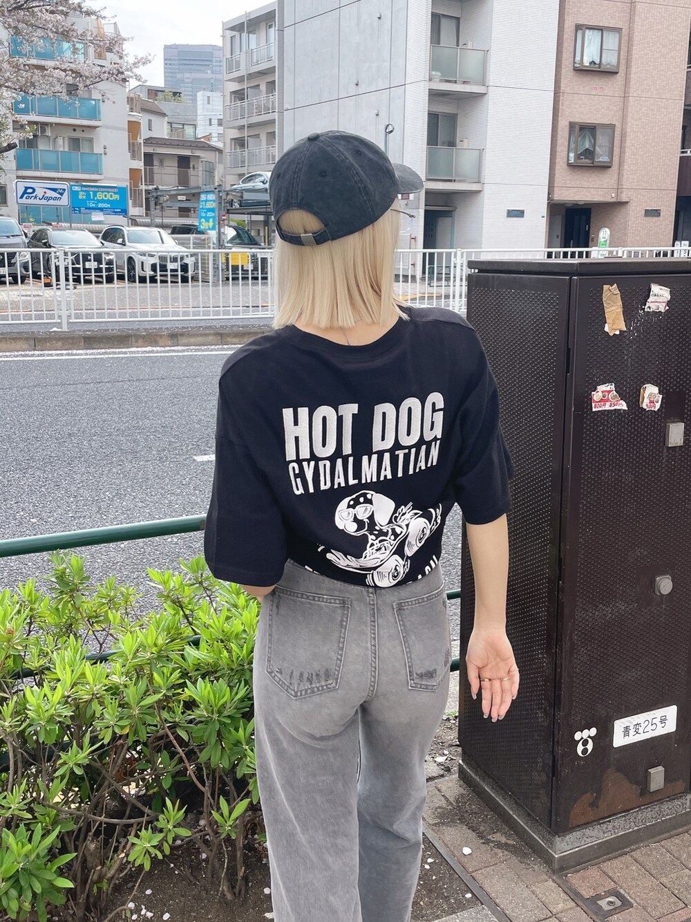 ブラック系のTシャツ/カットソー、グレー系のデニムパンツ、ブラック系のサンダルを着用したレディースの春コーディネートの4枚目の写真