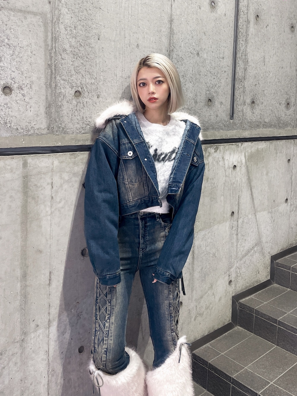 ブルー系のデニムジャケット、ブルー系のデニムパンツ、ホワイト系のブーツを着用したレディースの秋コーディネートの3枚目の写真
