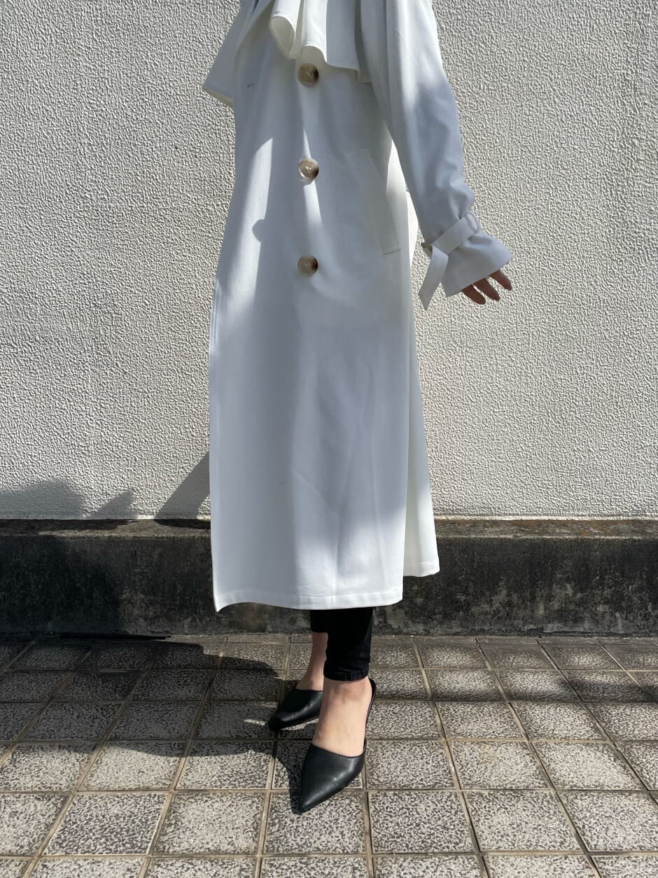 ブラック系のパンプス、ホワイト系のトレンチコートを着用したレディースの春コーディネートの7枚目の写真
