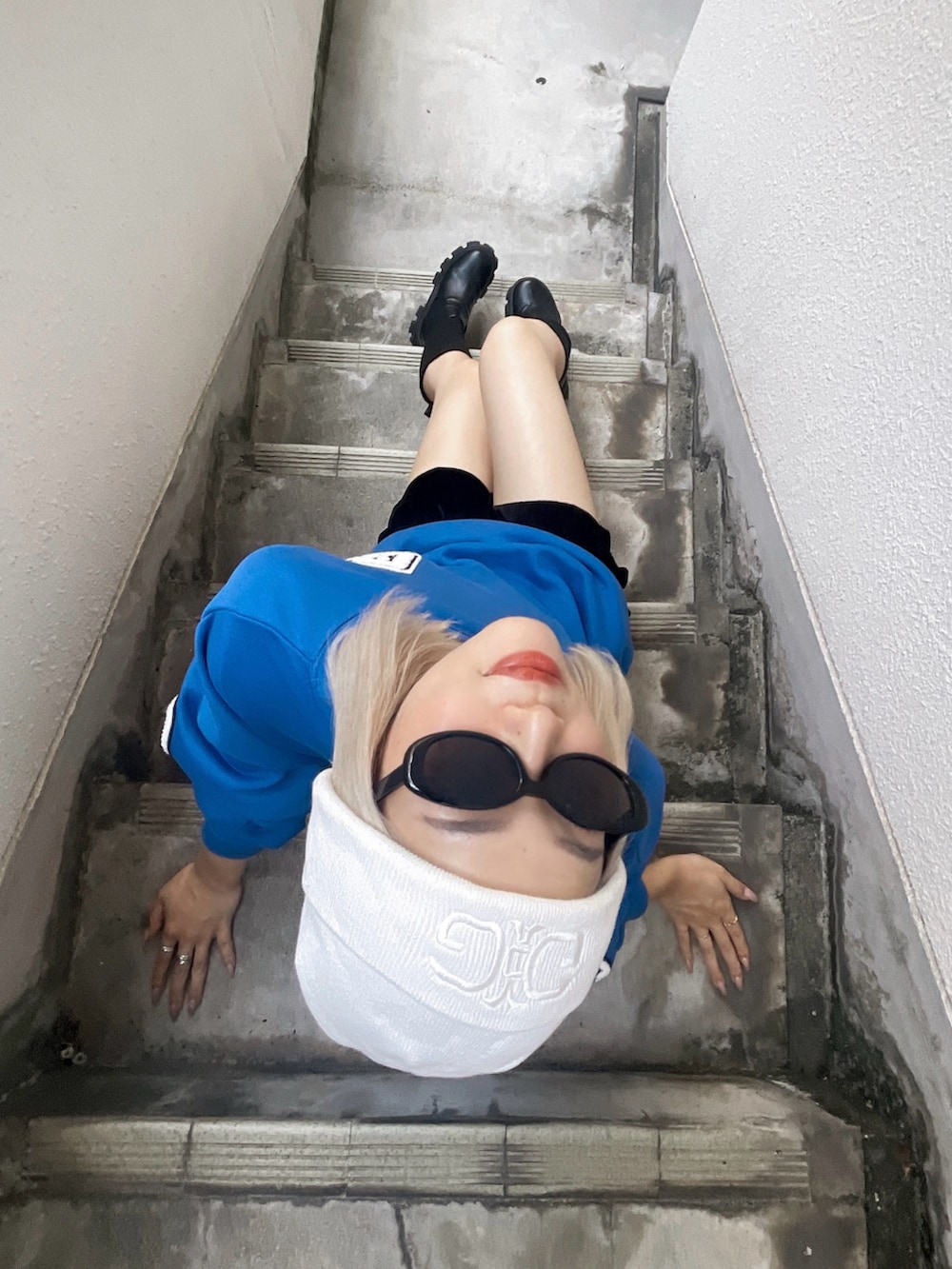 ブルー系のスウェット、ブラック系のハンドバッグ、ブラック系のブーツを着用したレディースの秋コーディネートの3枚目の写真