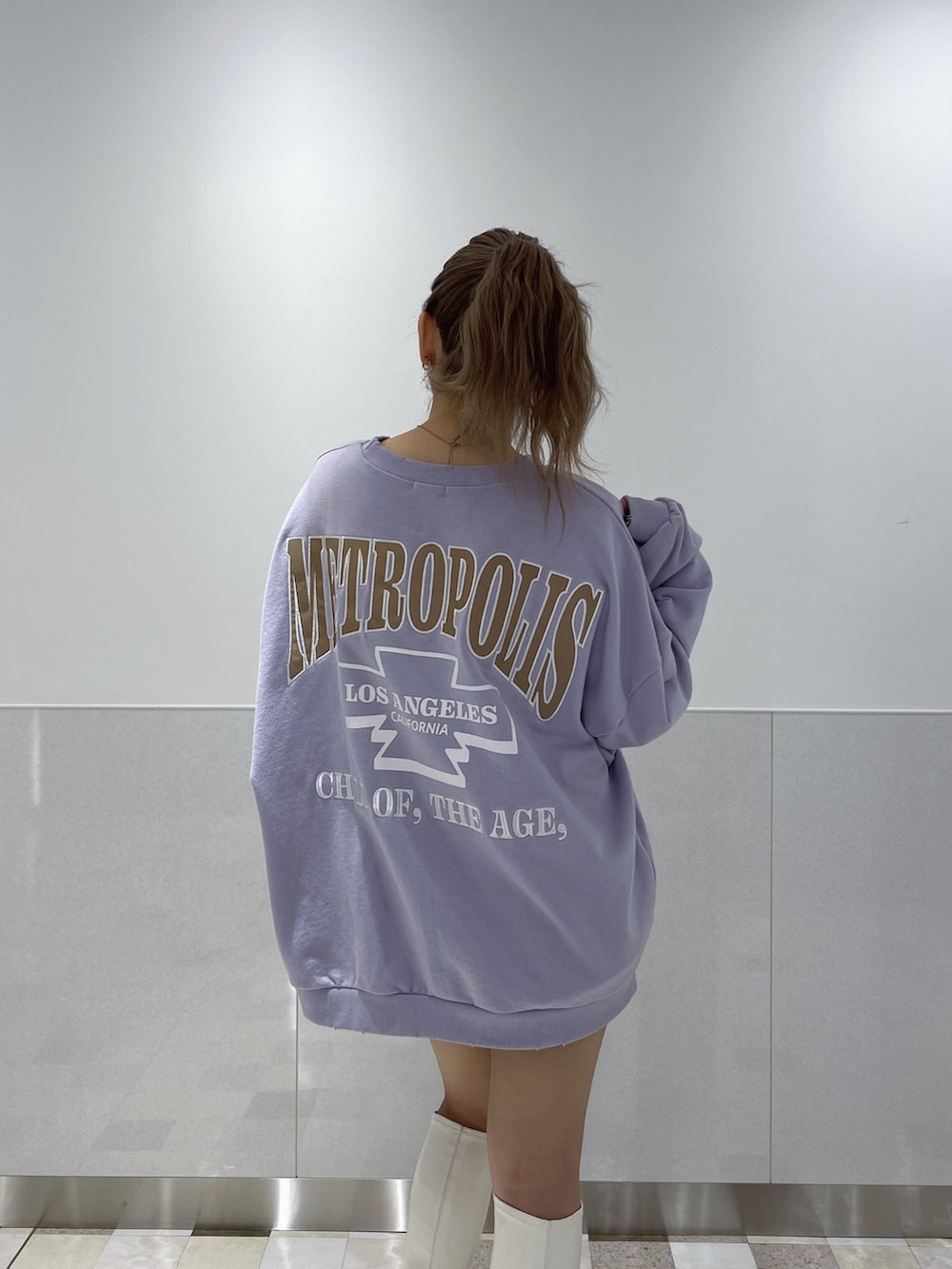 パープル系のスウェット、ホワイト系のブーツを着用したレディースの冬コーディネートの4枚目の写真