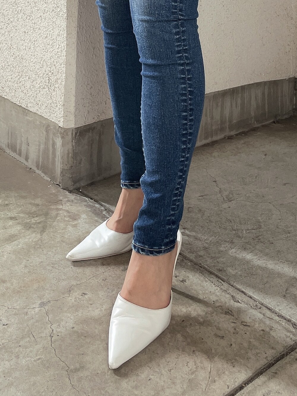 ブルー系のデニムパンツ、ホワイト系のニット/セーター、ホワイト系のパンプスを着用したレディースの夏コーディネートの7枚目の写真