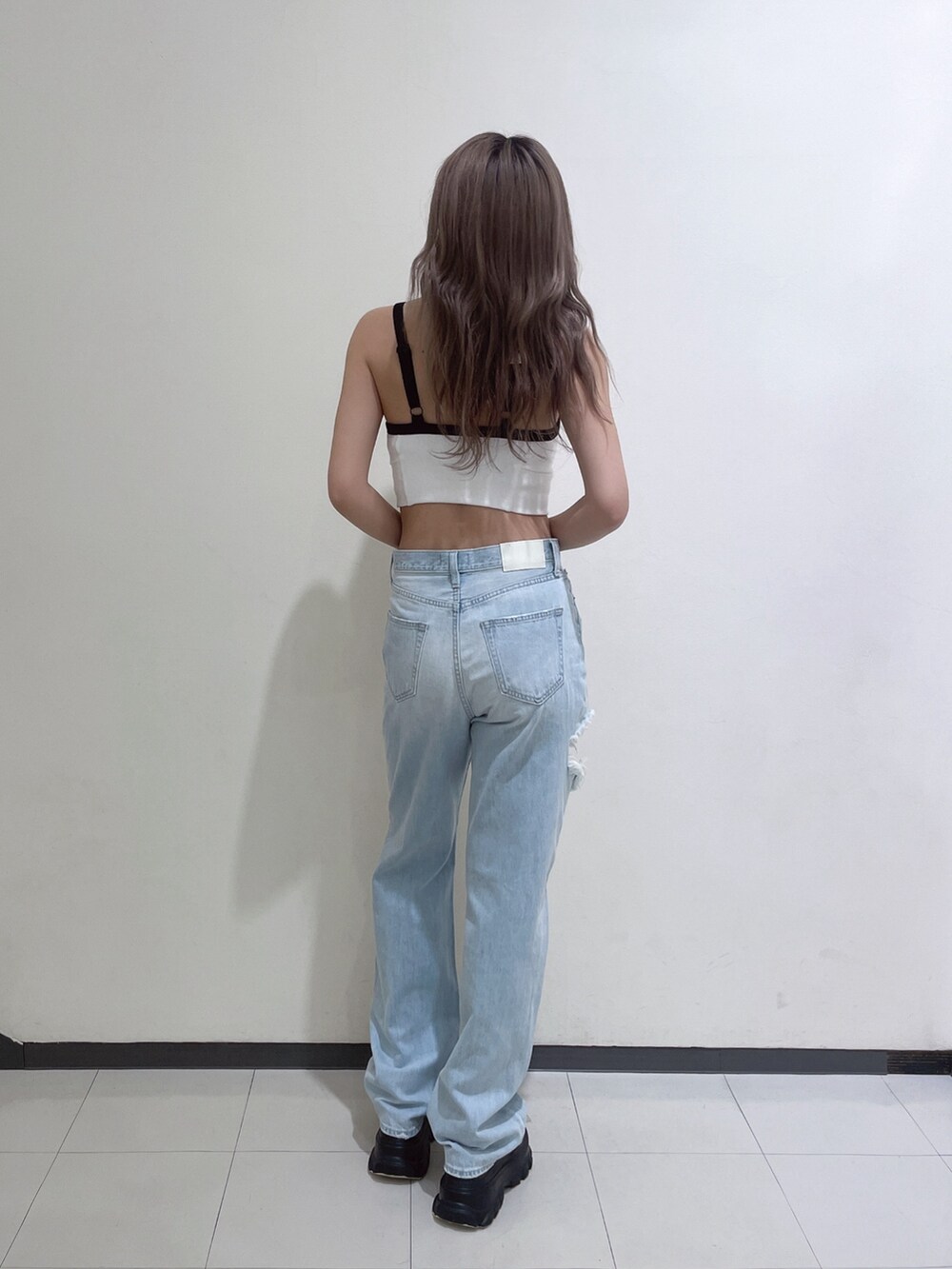 ホワイト系のキャミソール、ブルー系のデニムパンツ、グレー系のヘアバンドを着用したレディースの春コーディネートの3枚目の写真