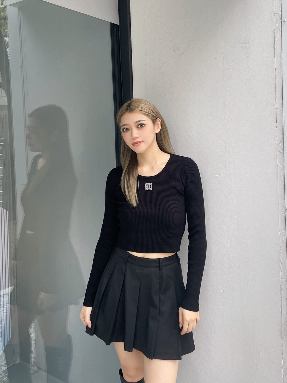 ブラック系のニット/セーター、ブラック系のスカート、ブラック系のブーツを着用したレディースの秋コーディネートの4枚目の写真