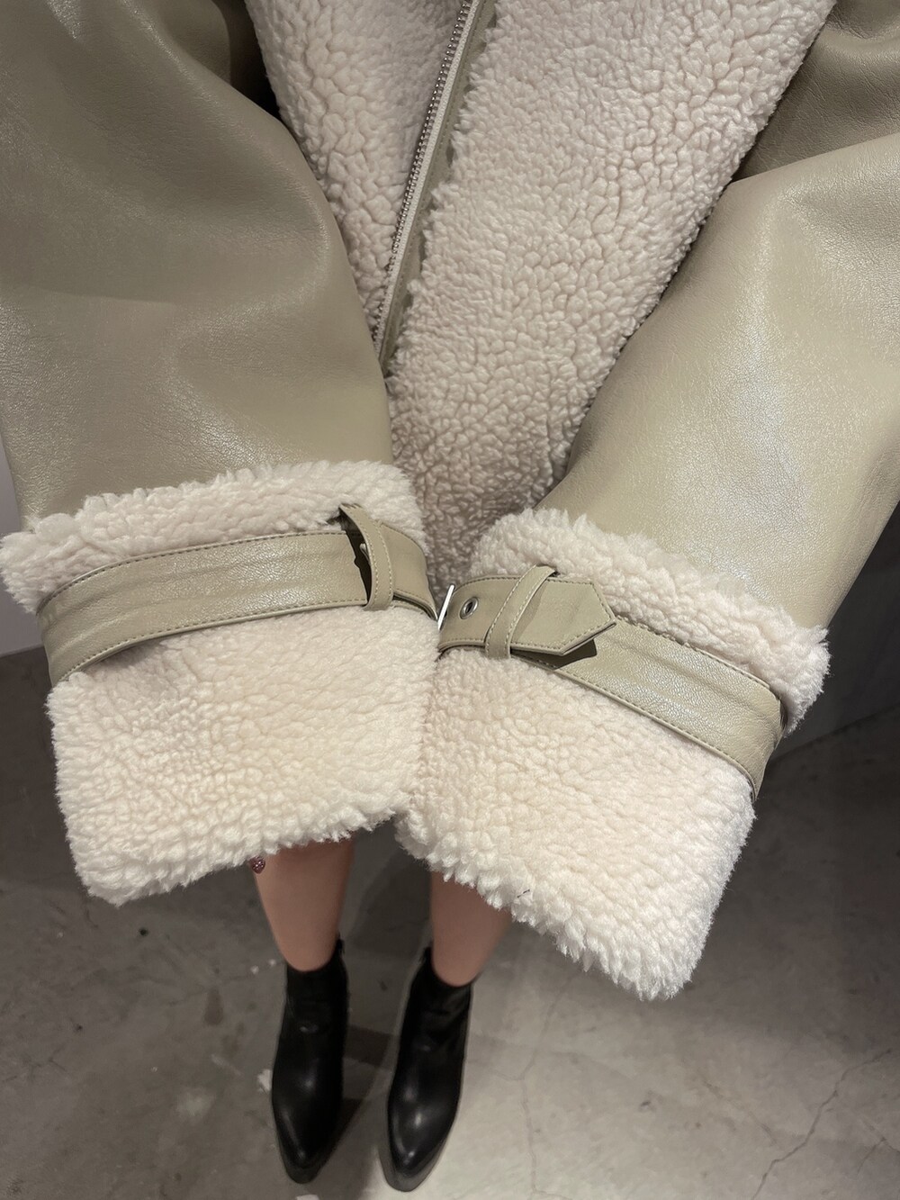 ベージュ系のブルゾン、ブラック系のブーツを着用したレディースの冬コーディネートの6枚目の写真