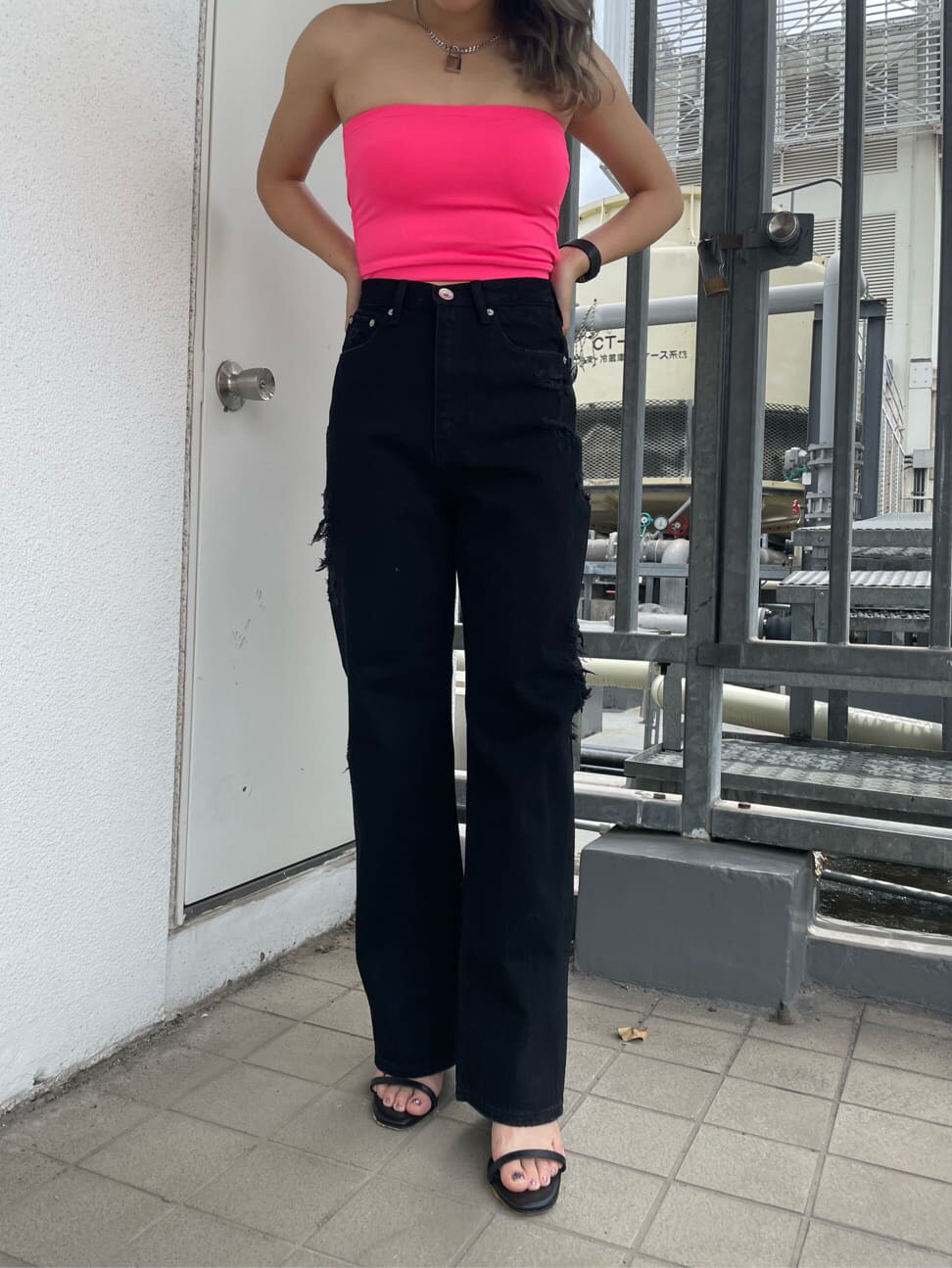 ブラック系のサンダル、ブラック系のデニムパンツ、ピンク系のチューブトップを着用したレディースの夏コーディネートの5枚目の写真