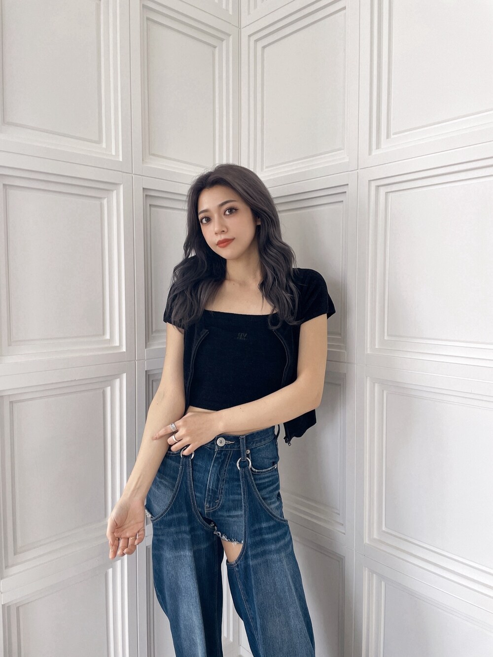 ブラック系のアンサンブル、ブルー系のデニムパンツを着用したレディースの夏コーディネートの2枚目の写真