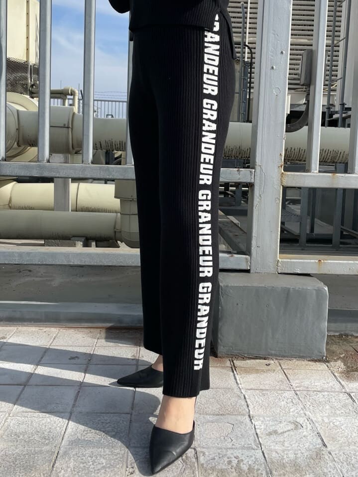 ブラック系のパンプス、ホワイト系のダウンジャケット/コート、ブラック系のその他パンツを着用したレディースの冬コーディネートの7枚目の写真