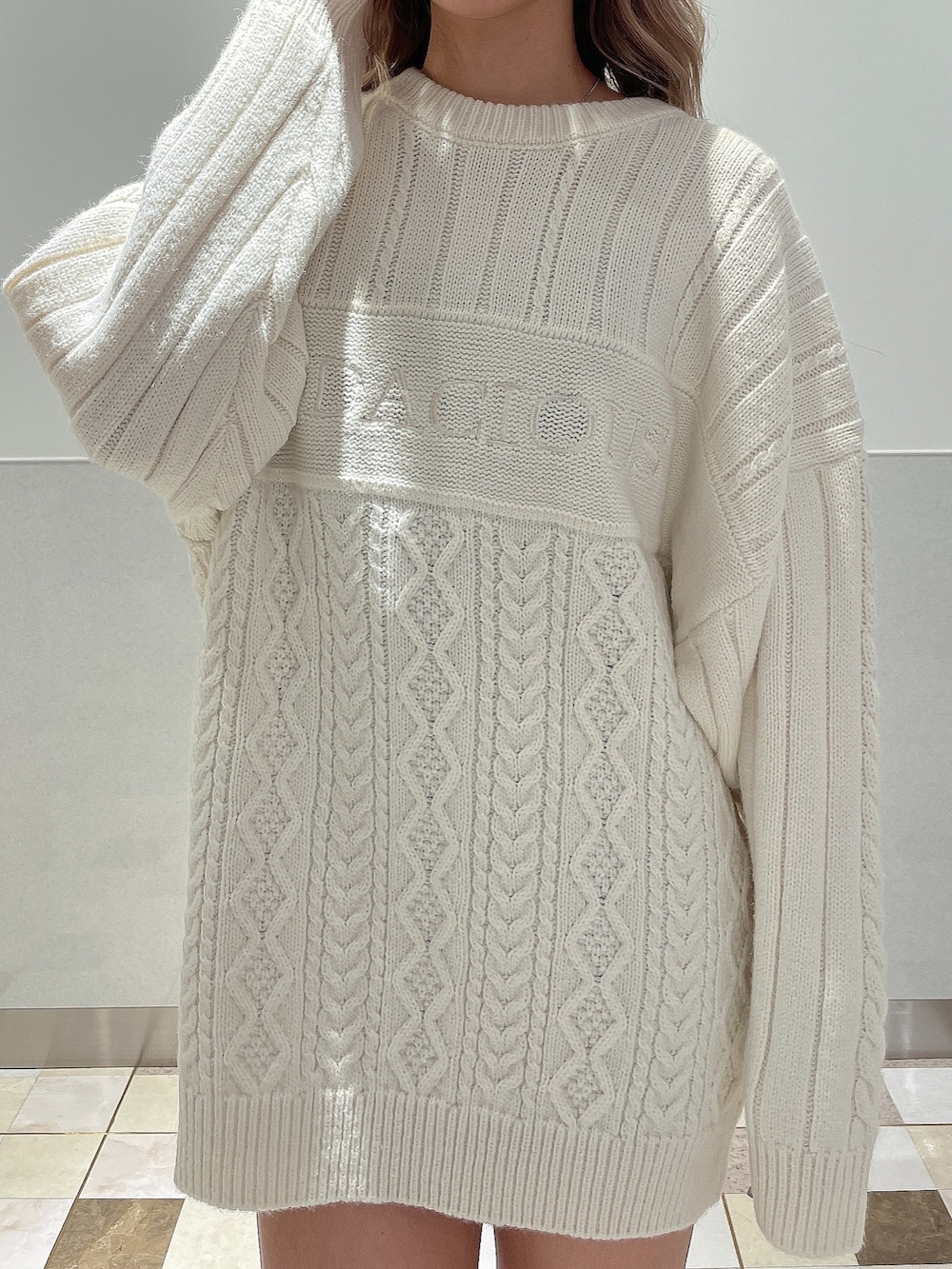 ホワイト系のニット/セーター、ブラック系のブーツを着用したレディースの秋コーディネートの5枚目の写真