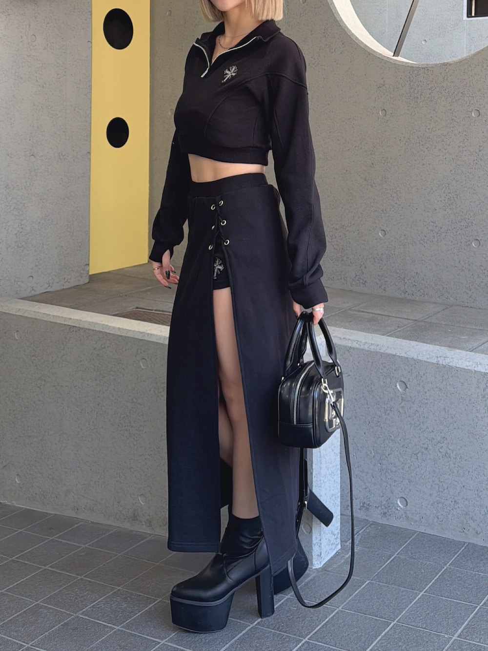 ブラック系のスウェット、ブラック系のスカート、ブラック系のハンドバッグを着用したレディースの冬コーディネートの3枚目の写真