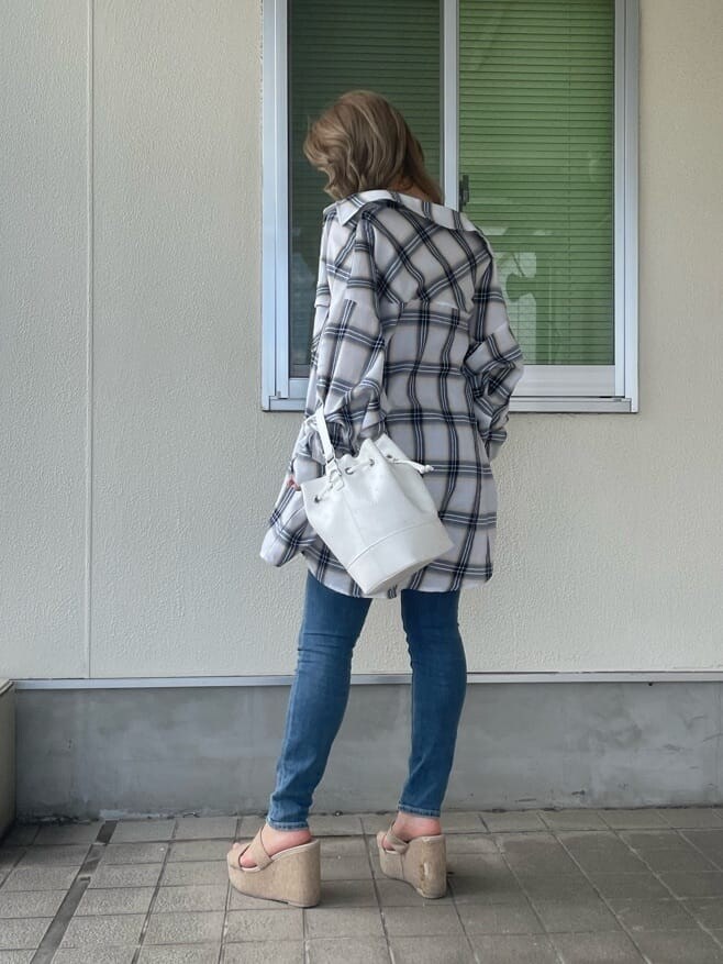 ホワイト系のシャツ/ブラウス、ホワイト系のハンドバッグ、ブルー系のデニムパンツを着用したレディースの夏コーディネートの2枚目の写真