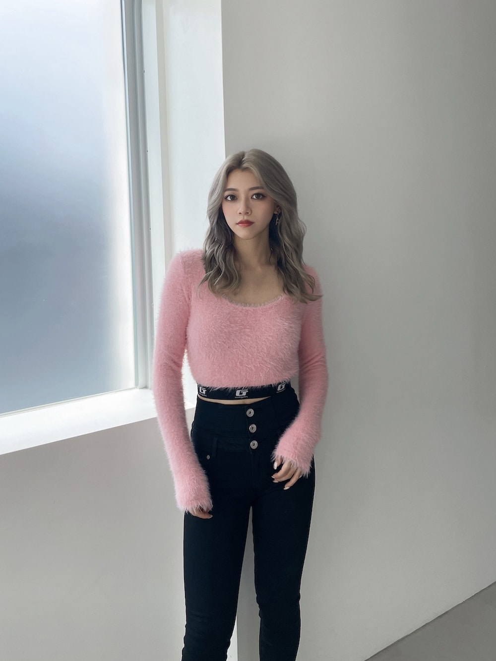 ピンク系のニット/セーター、ブラック系のデニムパンツ、ブラック系のパンプスを着用したレディースの冬コーディネートの4枚目の写真