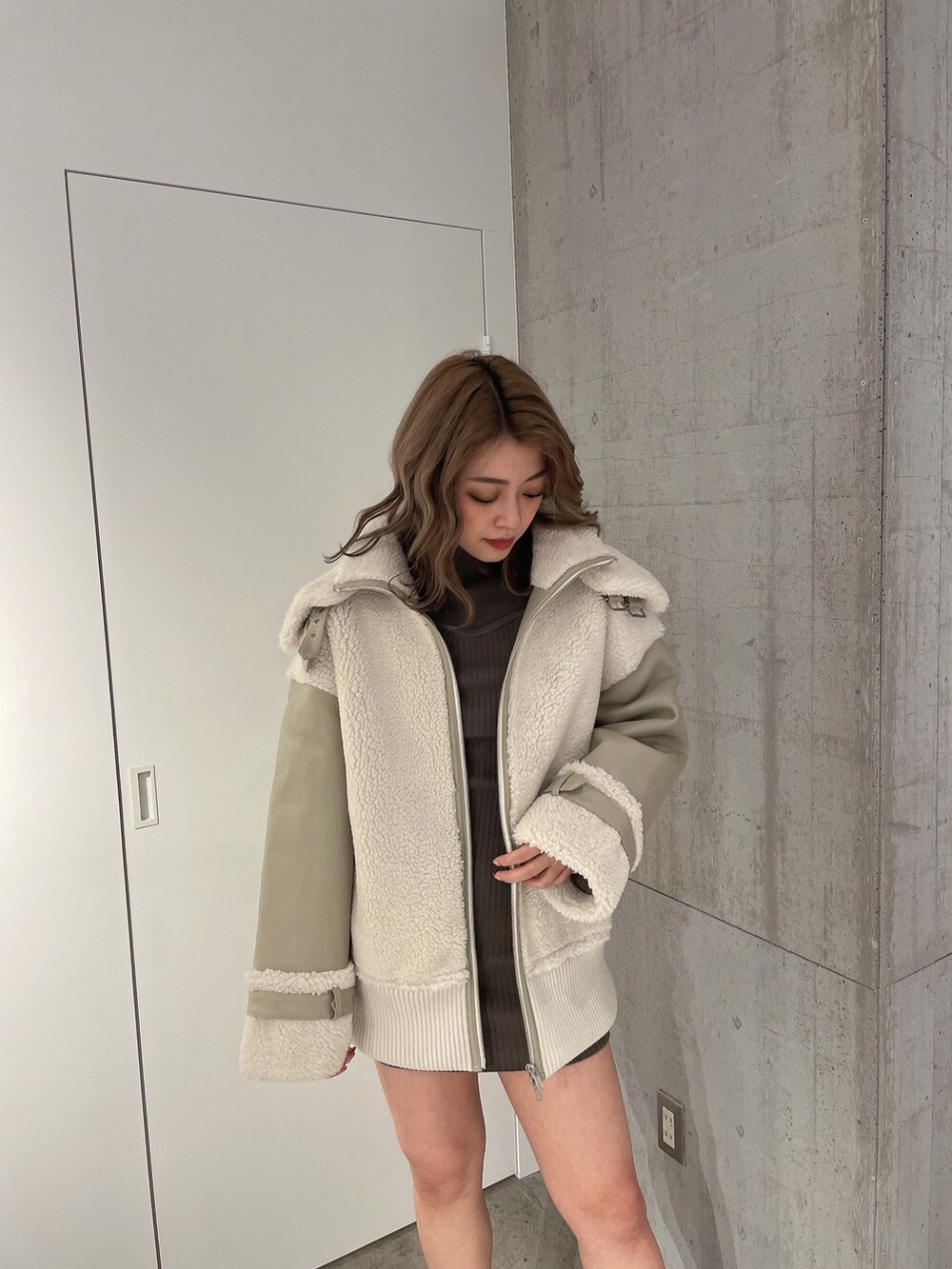 ベージュ系のブルゾン、ブラック系のブーツを着用したレディースの冬コーディネートの4枚目の写真