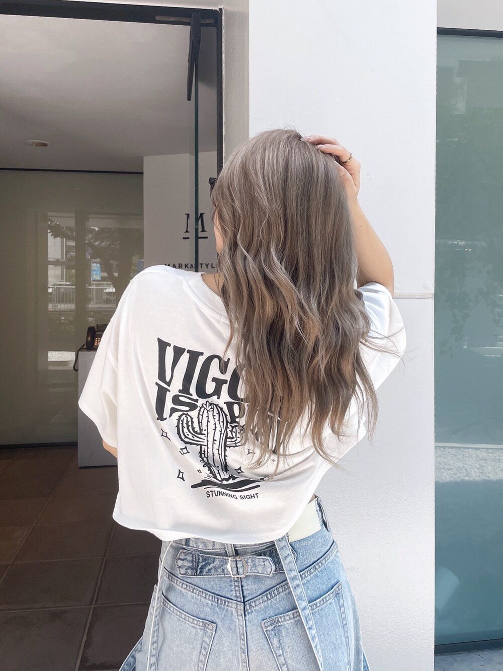 ホワイト系のTシャツ/カットソー、ブルー系のデニムパンツ、ホワイト系のサンダルを着用したレディースの夏コーディネートの5枚目の写真