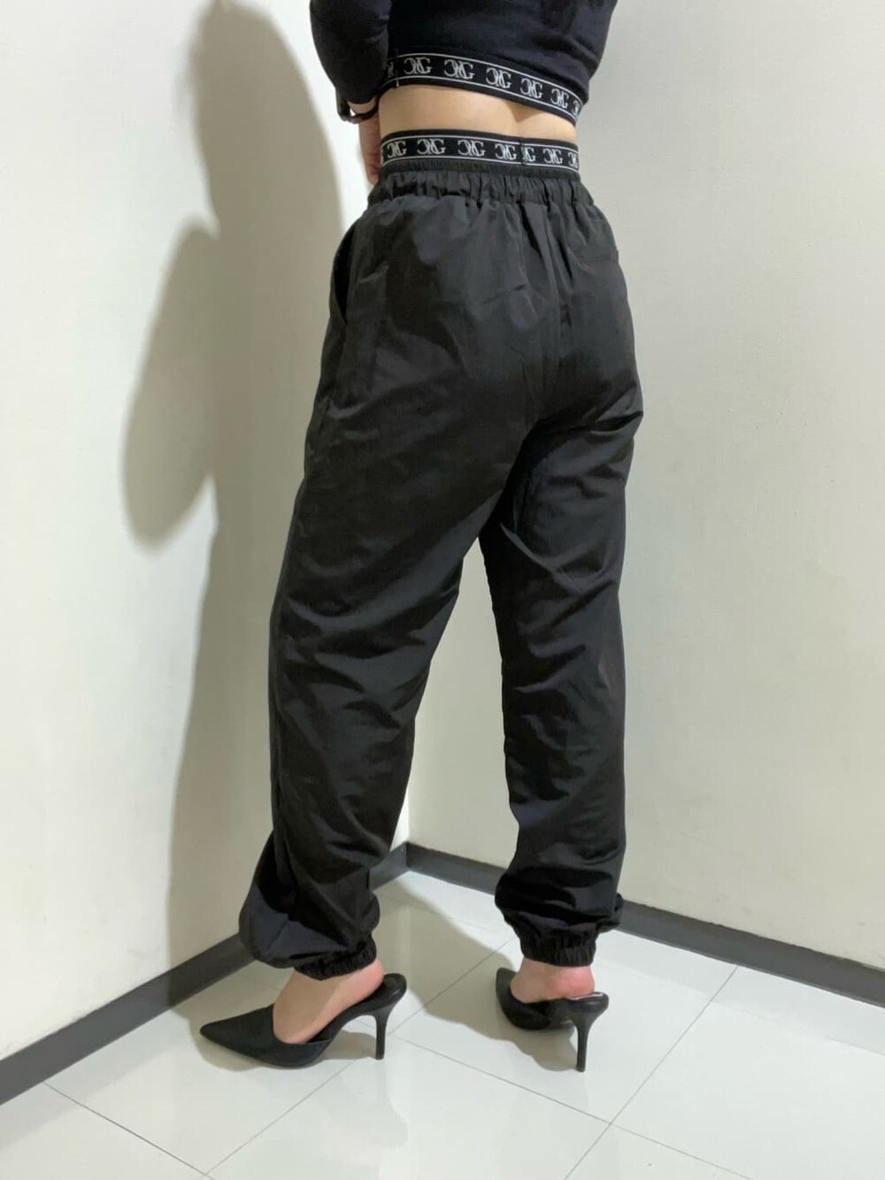 ブラック系のパンプス、ブラック系のその他パンツ、ブラック系のTシャツ/カットソーを着用したレディースの秋コーディネートの6枚目の写真