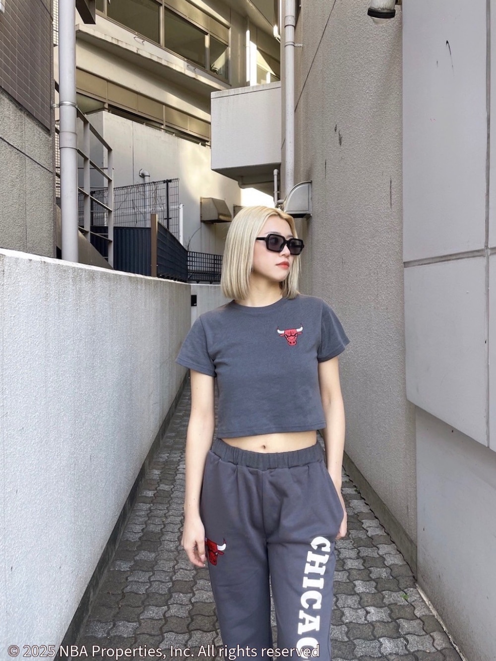グレー系のTシャツ/カットソー、グレー系のスウェットパンツ、ブラック系のサンダルを着用したレディースの夏コーディネートの3枚目の写真