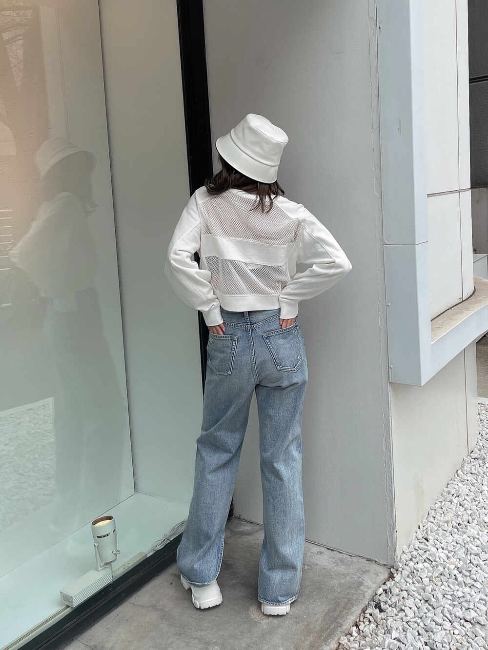 ホワイト系のスウェット、ブルー系のデニムパンツ、ホワイト系のスニーカーを着用したレディースの冬コーディネートの3枚目の写真