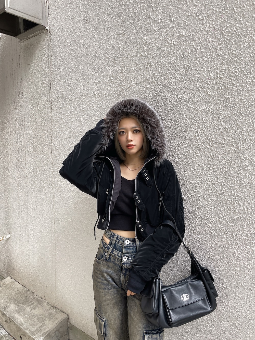 ブラック系のブルゾン、ブラック系のデニムパンツ、ブラック系のブーツを着用したレディースの秋コーディネートの5枚目の写真