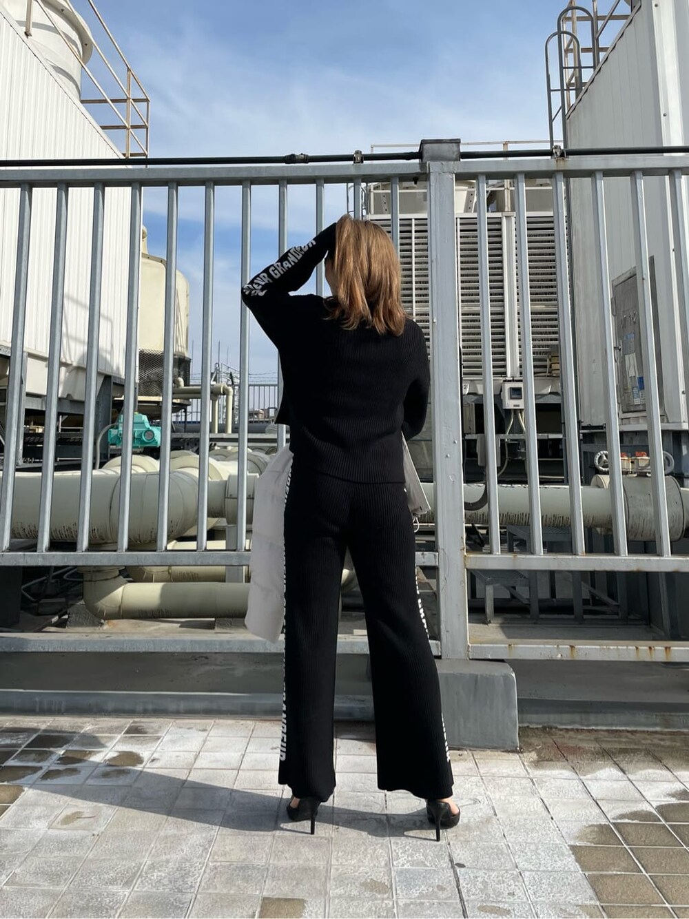 ブラック系のパンプス、ホワイト系のダウンジャケット/コート、ブラック系のその他パンツを着用したレディースの冬コーディネートの5枚目の写真