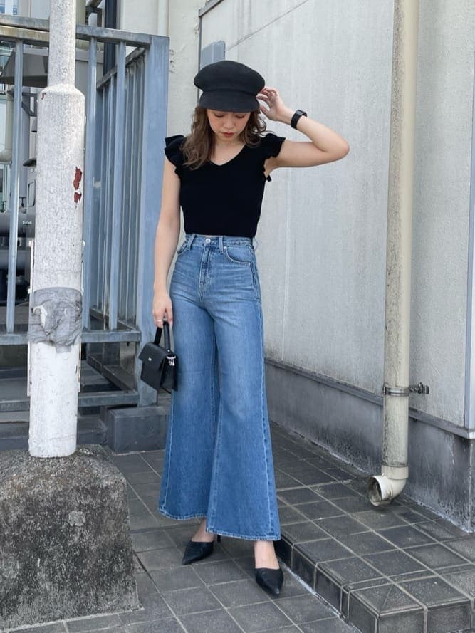 ブラック系のパンプス、ブラック系のハンドバッグ、ブラック系のニット/セーターを着用したレディースの春コーディネートの2枚目の写真