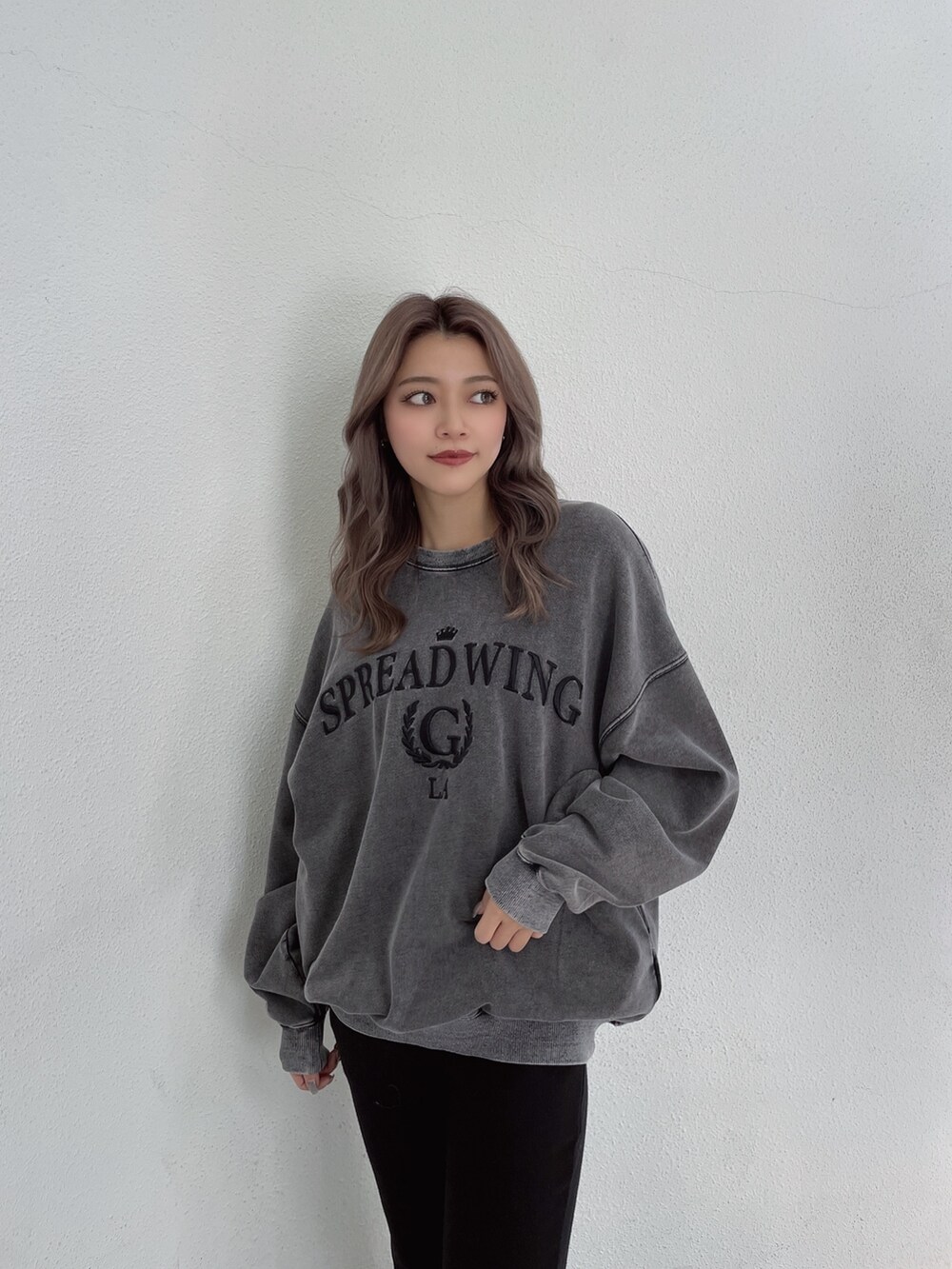 グレー系のスウェット、ブラック系のスウェットパンツ、ブラック系のパンプスを着用したレディースの冬コーディネートの4枚目の写真