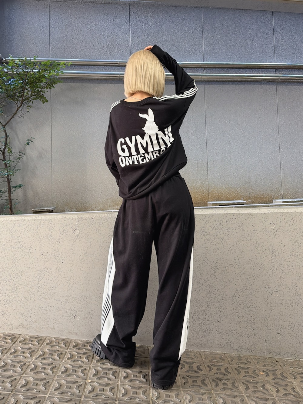 ブラック系のスウェットパンツ、ブラック系のスウェット、ブラック系のブーツを着用したレディースの冬コーディネートの2枚目の写真