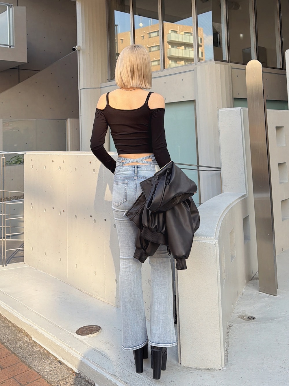 ブラック系のTシャツ/カットソー、ブルー系のデニムパンツ、ブラック系のブーツを着用したレディースの冬コーディネートの3枚目の写真