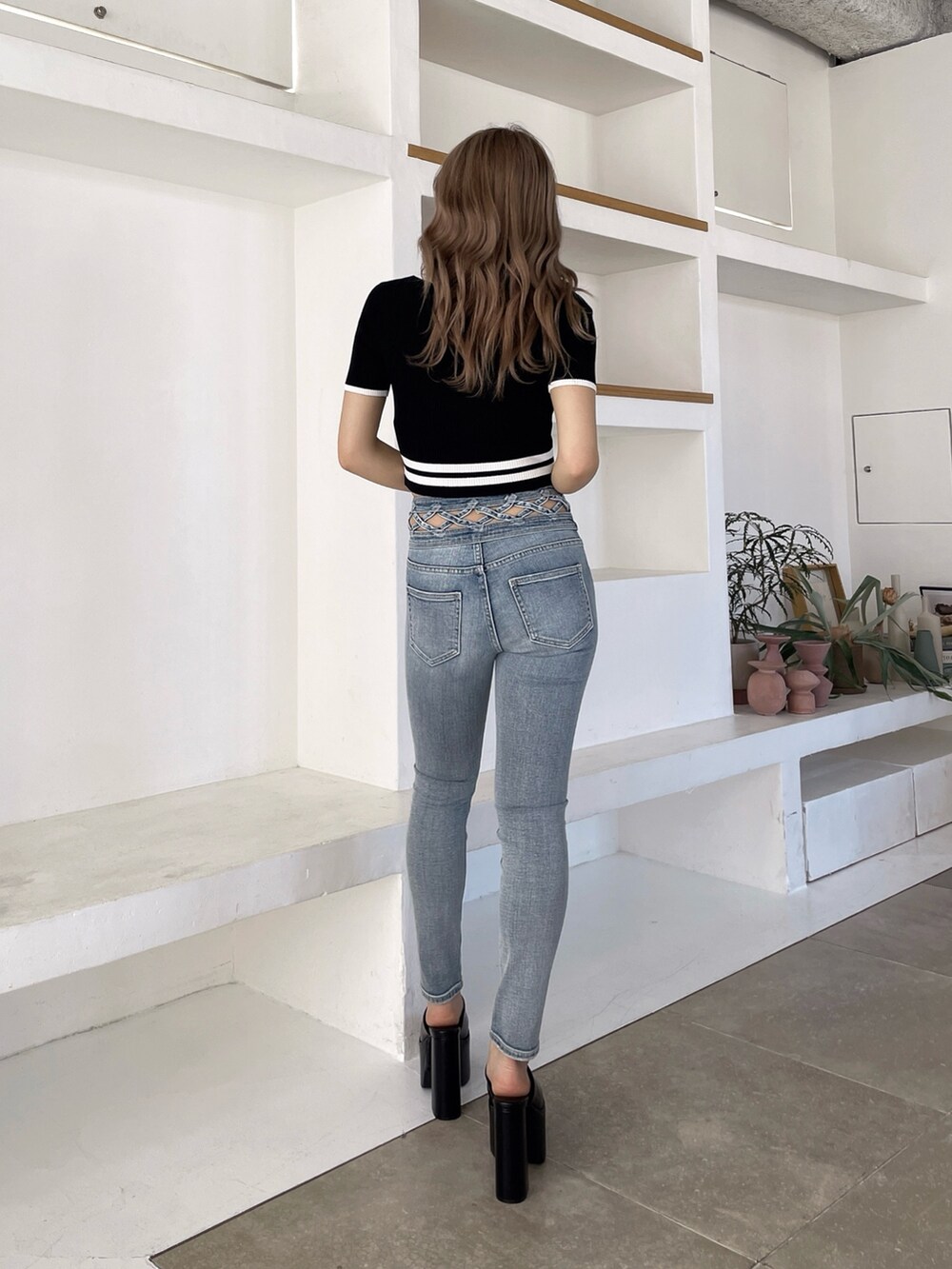 ブラック系のサンダル、ブルー系のデニムパンツ、ブラック系のニット/セーターを着用したレディースの春コーディネートの3枚目の写真