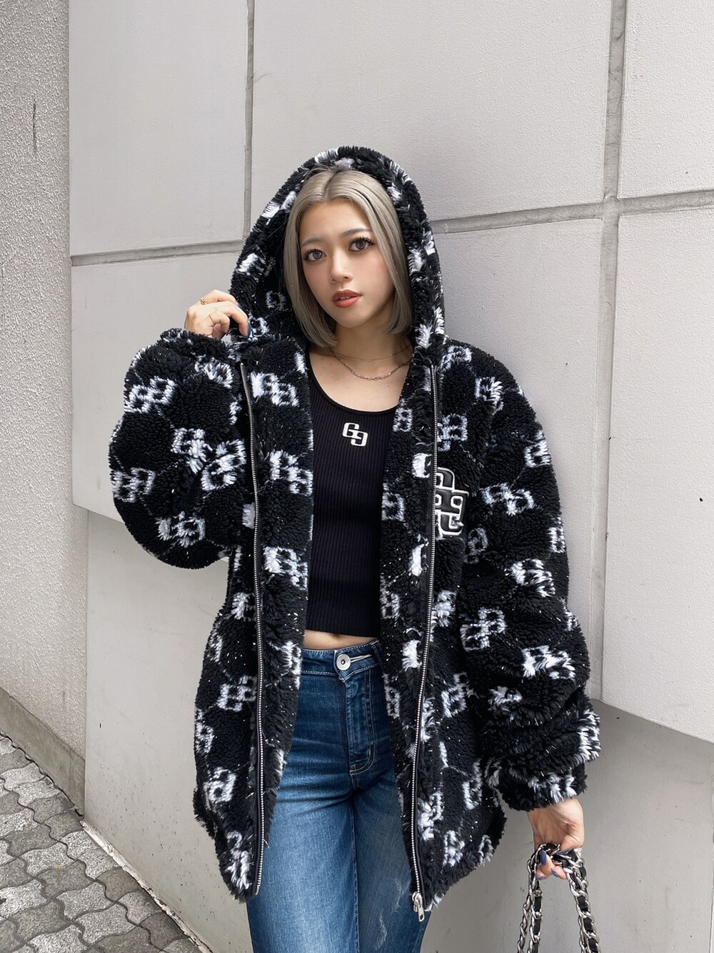 ブラック系のブルゾン、ブラック系のニット/セーター、ブルー系のデニムパンツを着用したレディースの秋コーディネートの3枚目の写真