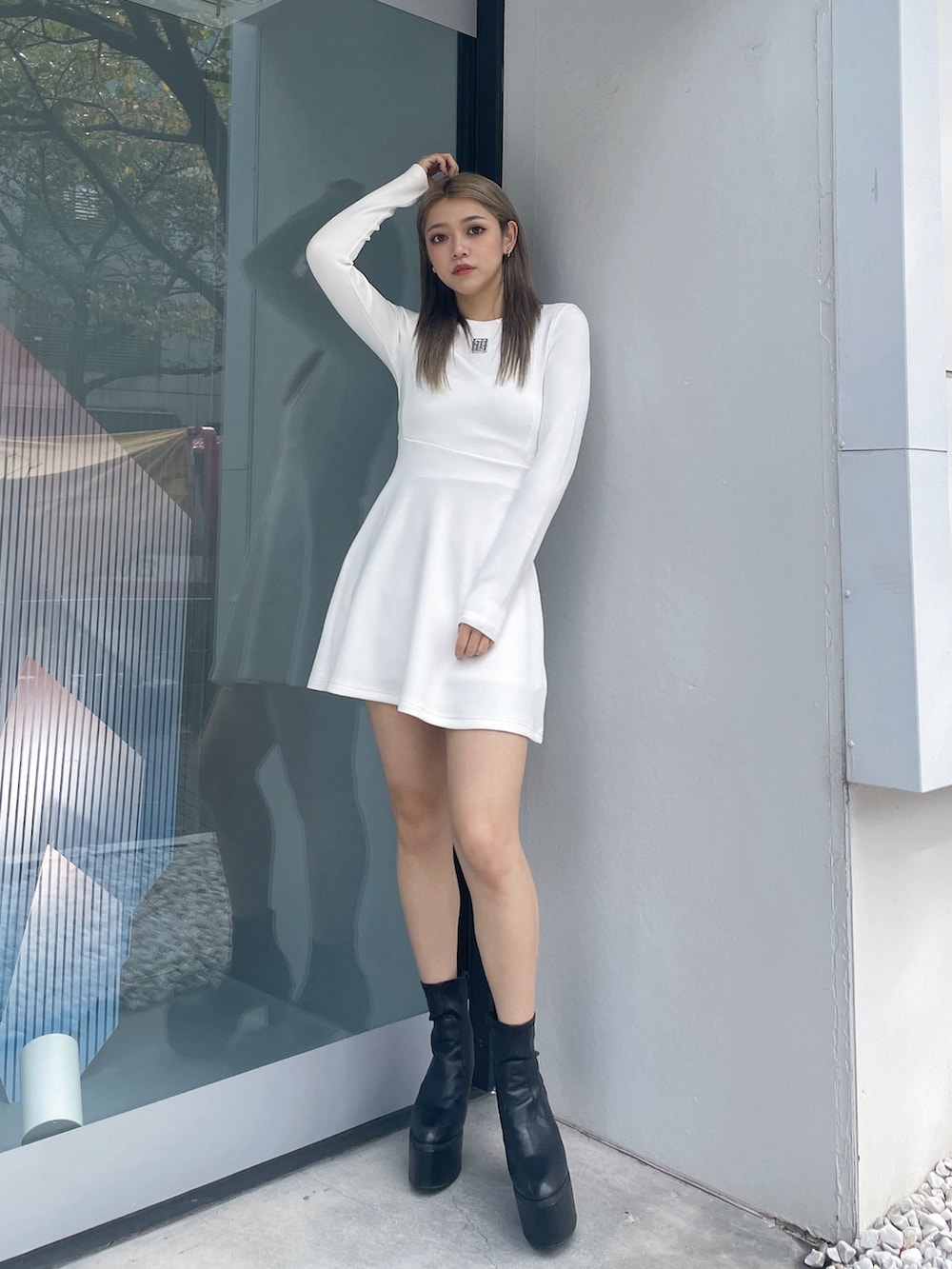 ホワイト系のワンピース、ブラック系のブーツを着用したレディースの秋コーディネートの2枚目の写真