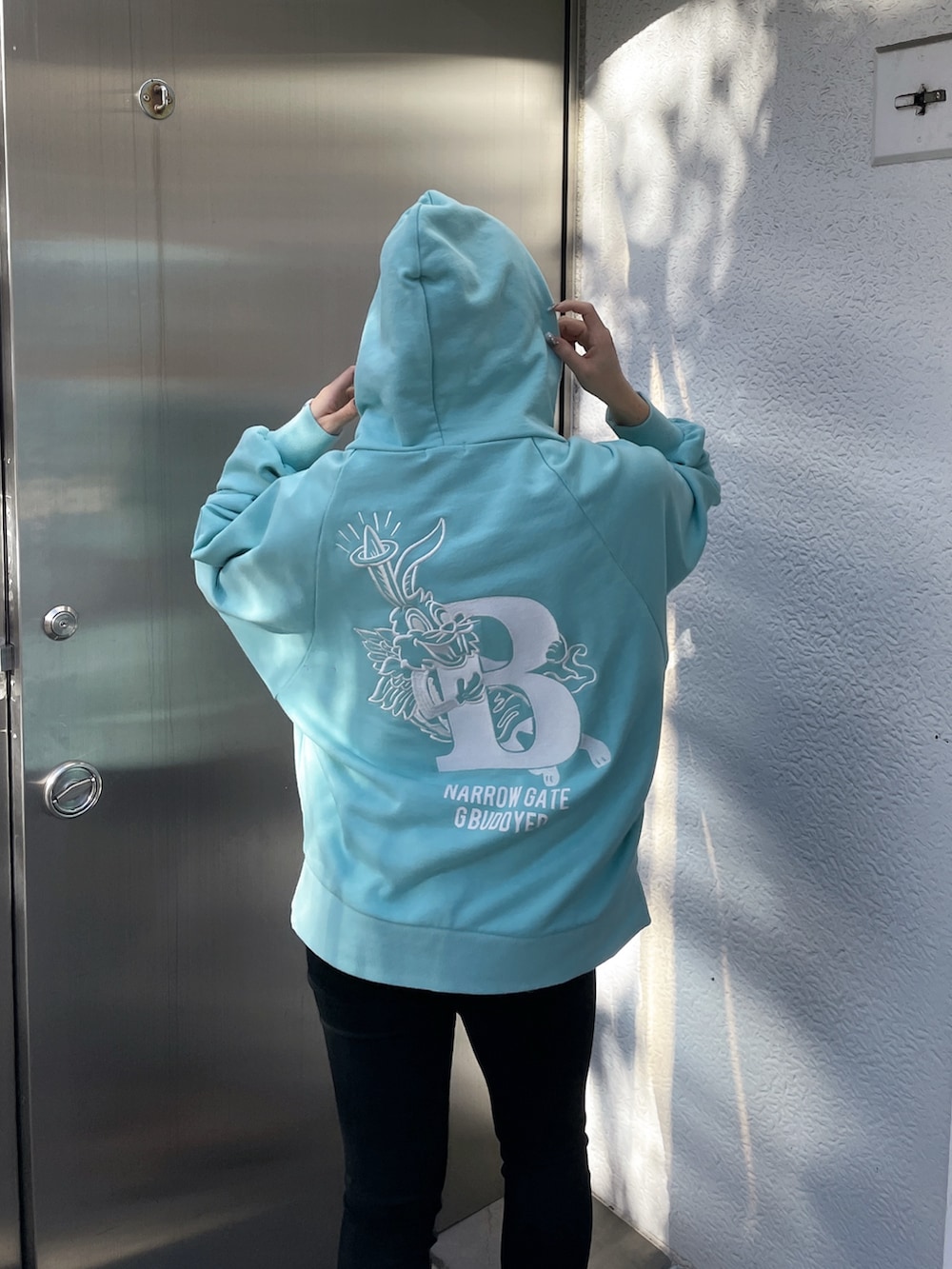 ブルー系のパーカー、ブラック系のデニムパンツを着用したレディースの冬コーディネートの2枚目の写真