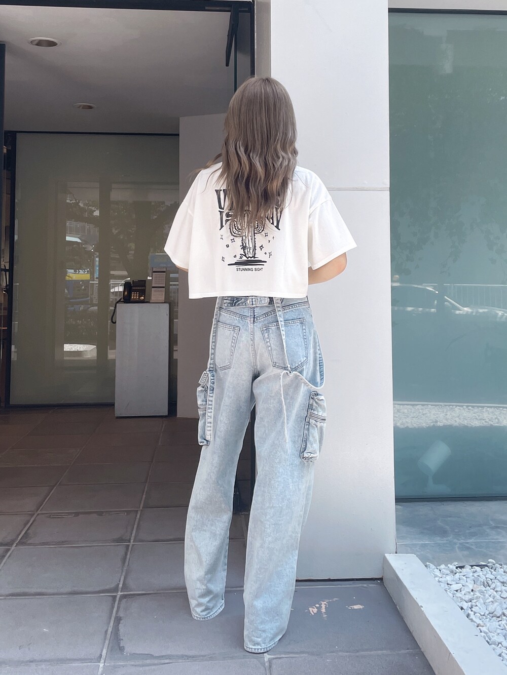 ホワイト系のTシャツ/カットソー、ブルー系のデニムパンツ、ホワイト系のサンダルを着用したレディースの夏コーディネートの3枚目の写真