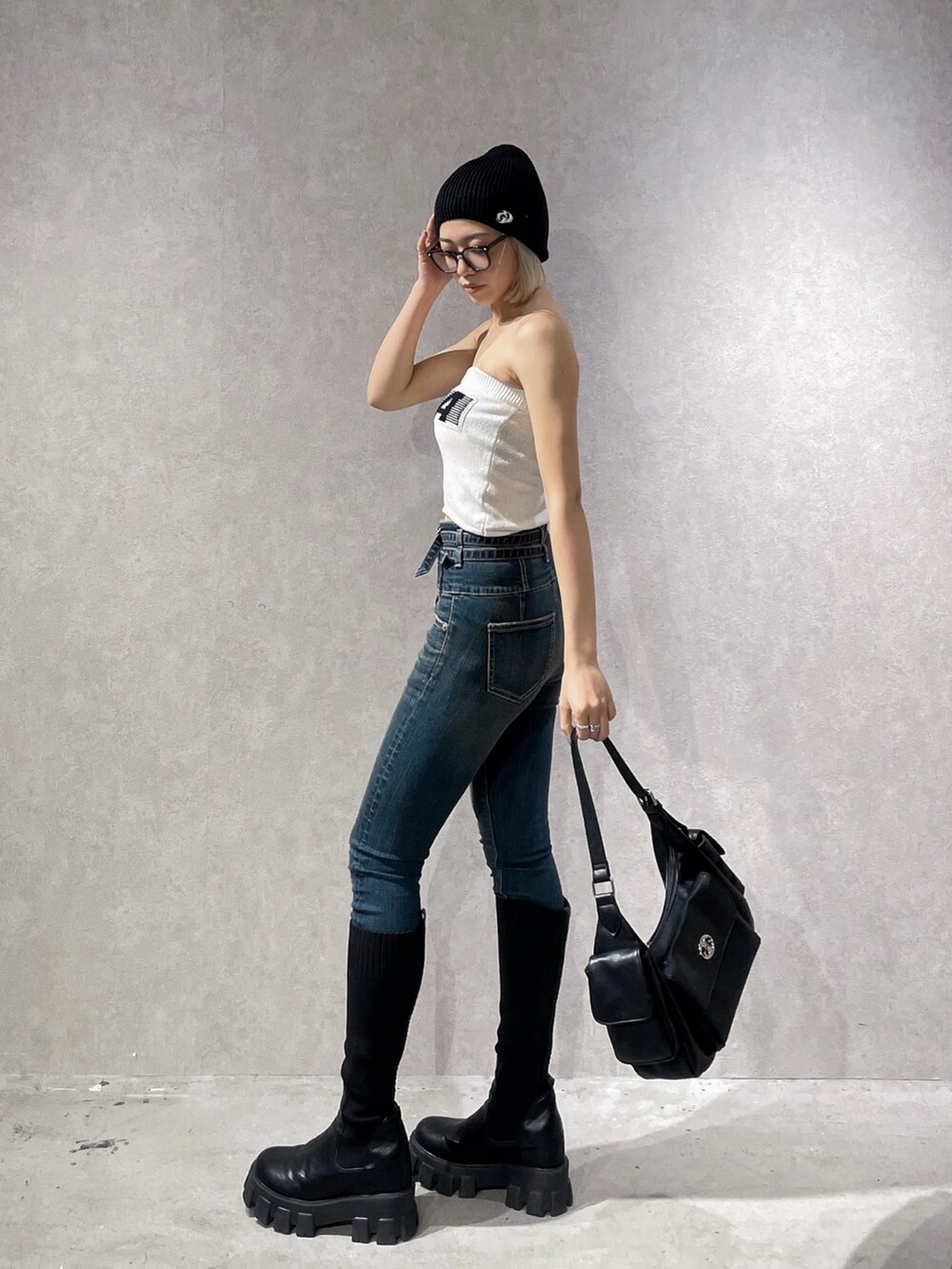 ホワイト系のニット/セーター、ブルー系のデニムパンツ、ブラック系のブーツを着用したレディースの夏コーディネートの3枚目の写真