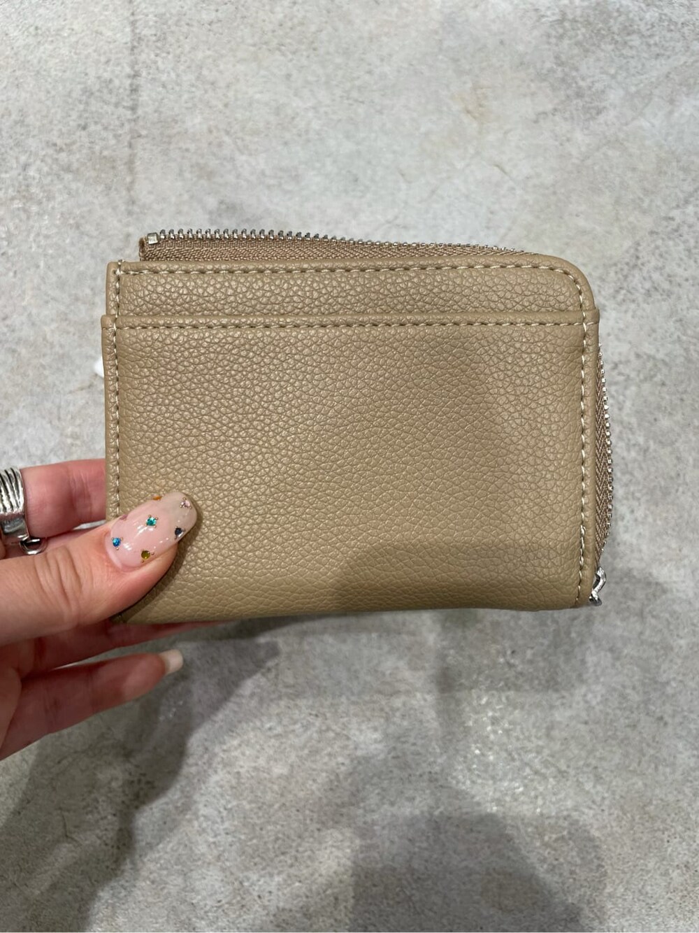 ベージュ系の財布を着用したレディースの秋コーディネートの2枚目の写真