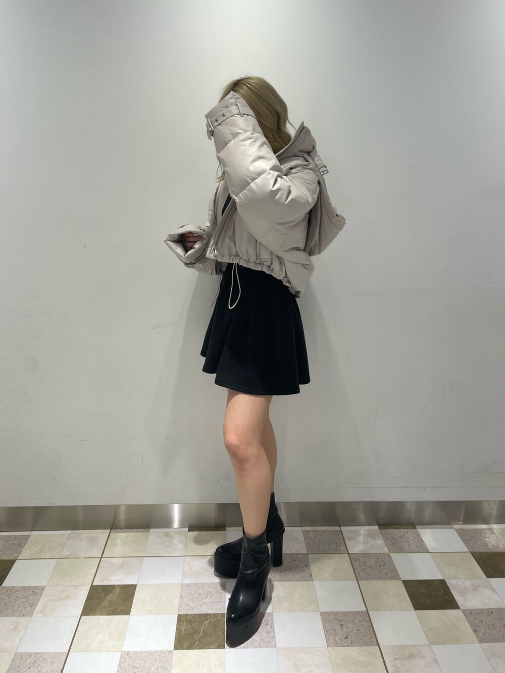 ブラック系のワンピース、ブラック系のブーツ、ホワイト系のダウンジャケット/コートを着用したレディースの冬コーディネートの3枚目の写真