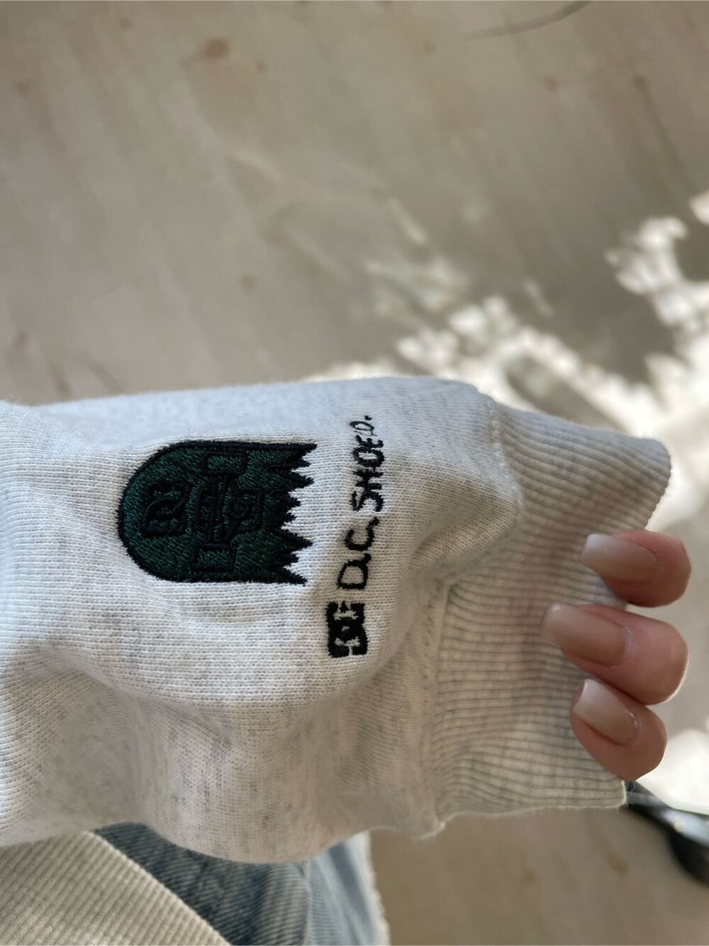 ブラック系のブーツ、グレー系のパーカー、ブルー系のデニムスカートを着用したレディースの冬コーディネートの7枚目の写真