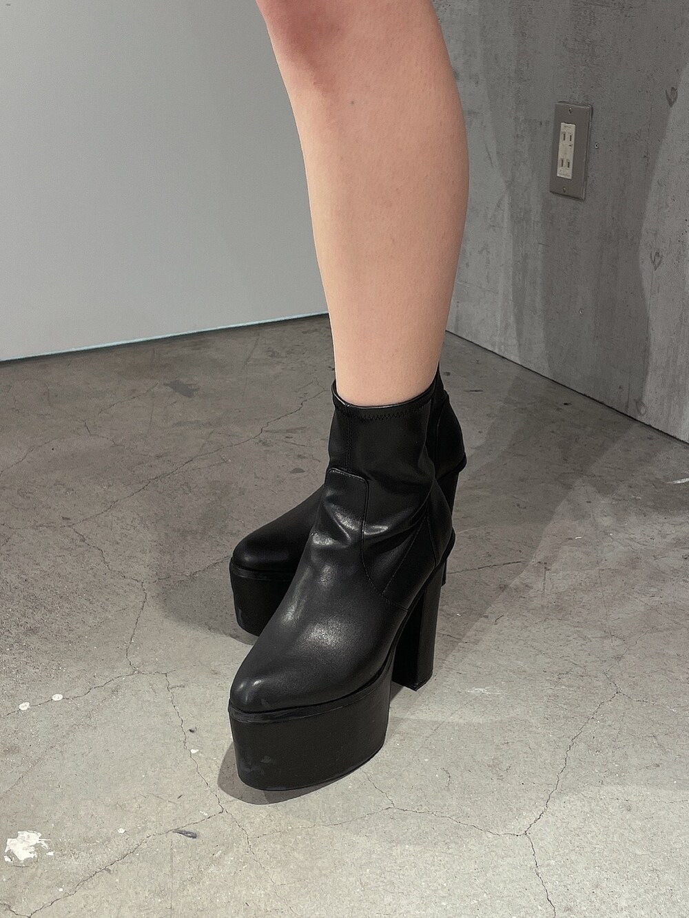 ホワイト系のブルゾン、グリーン系のワンピース、ブラック系のブーツを着用したレディースの冬コーディネートの8枚目の写真