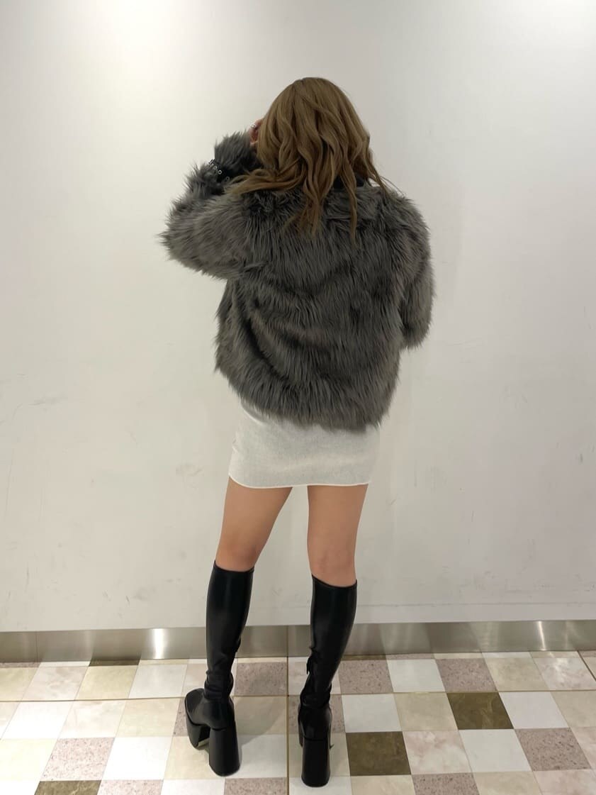 ブラック系のブーツ、グレー系のライダースジャケット、ホワイト系のワンピースを着用したレディースの秋コーディネートの2枚目の写真