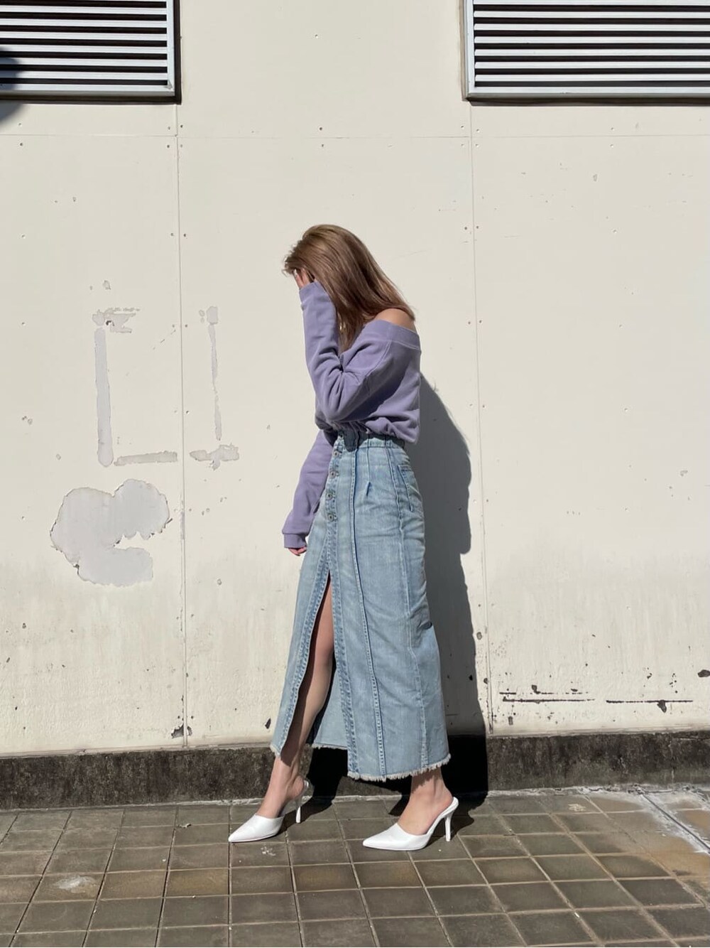 ホワイト系のパンプス、ブルー系のデニムスカート、パープル系のスウェットを着用したレディースの冬コーディネートの2枚目の写真