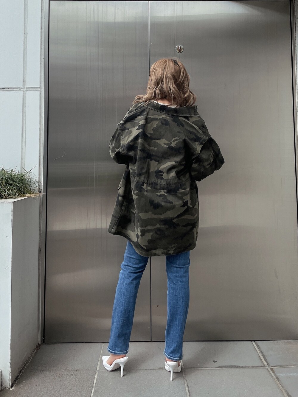 その他のミリタリージャケット、ブルー系のデニムパンツ、ホワイト系のスウェットを着用したレディースの春コーディネートの2枚目の写真